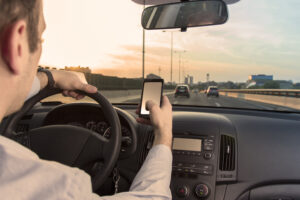 a person texting while driving a car