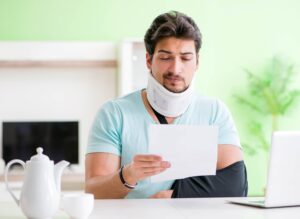 The young student man with neck and hand injury at home